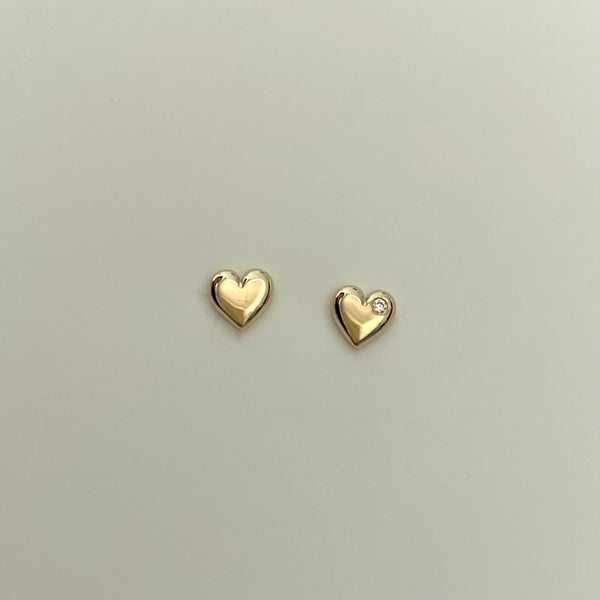 two 14 karat gold heart studs, one is set with a small diamond
