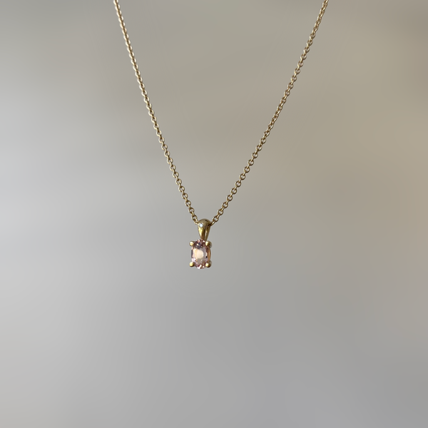 a gold pendant with morganite stone and a small diamond on a gold chain