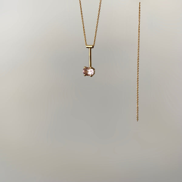 a 14 karat gold pendant with a pink morganite gemstone on white background
