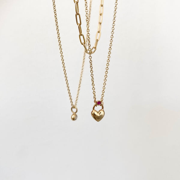 three gold chain necklaces on a white background