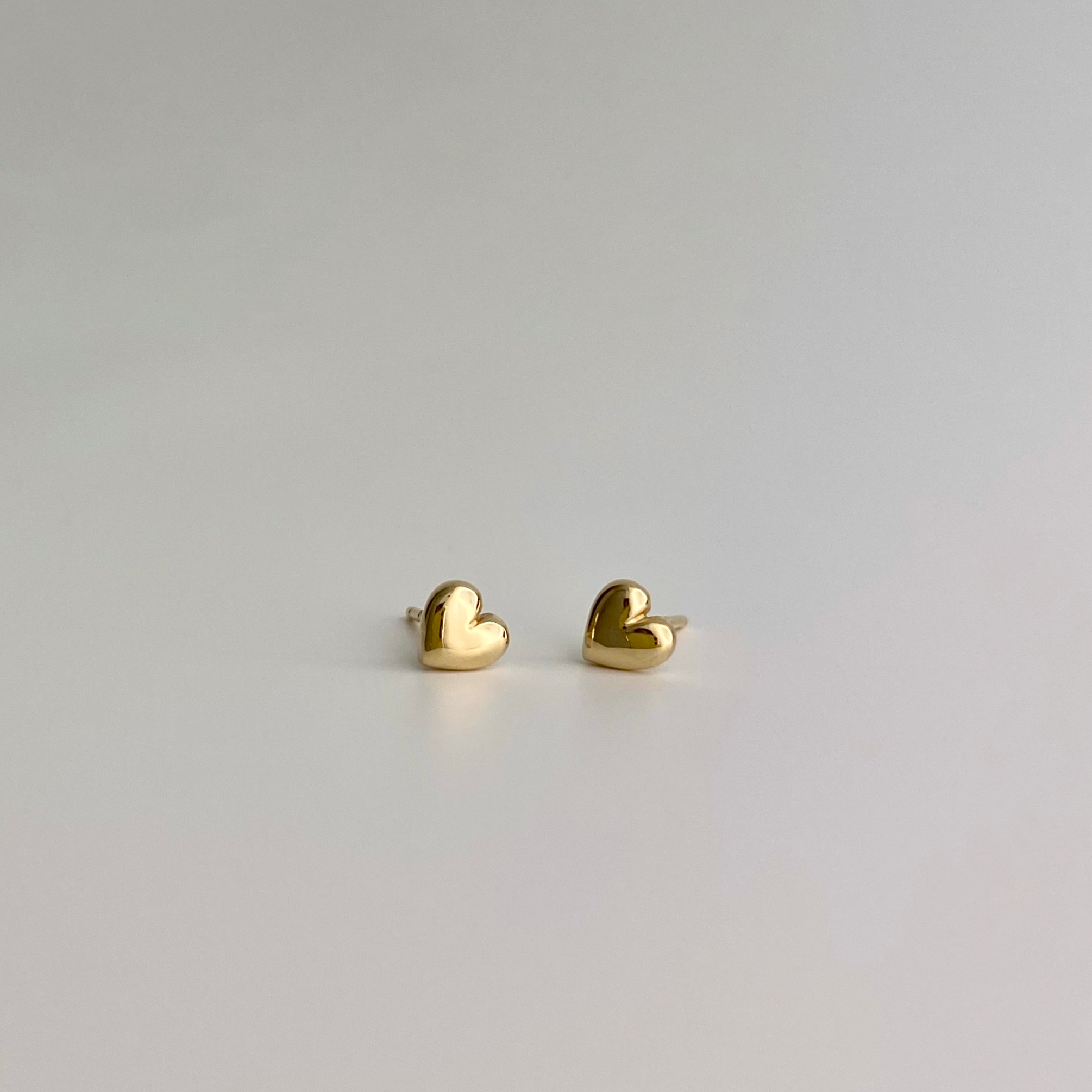 two dainty gold stud heart earrings