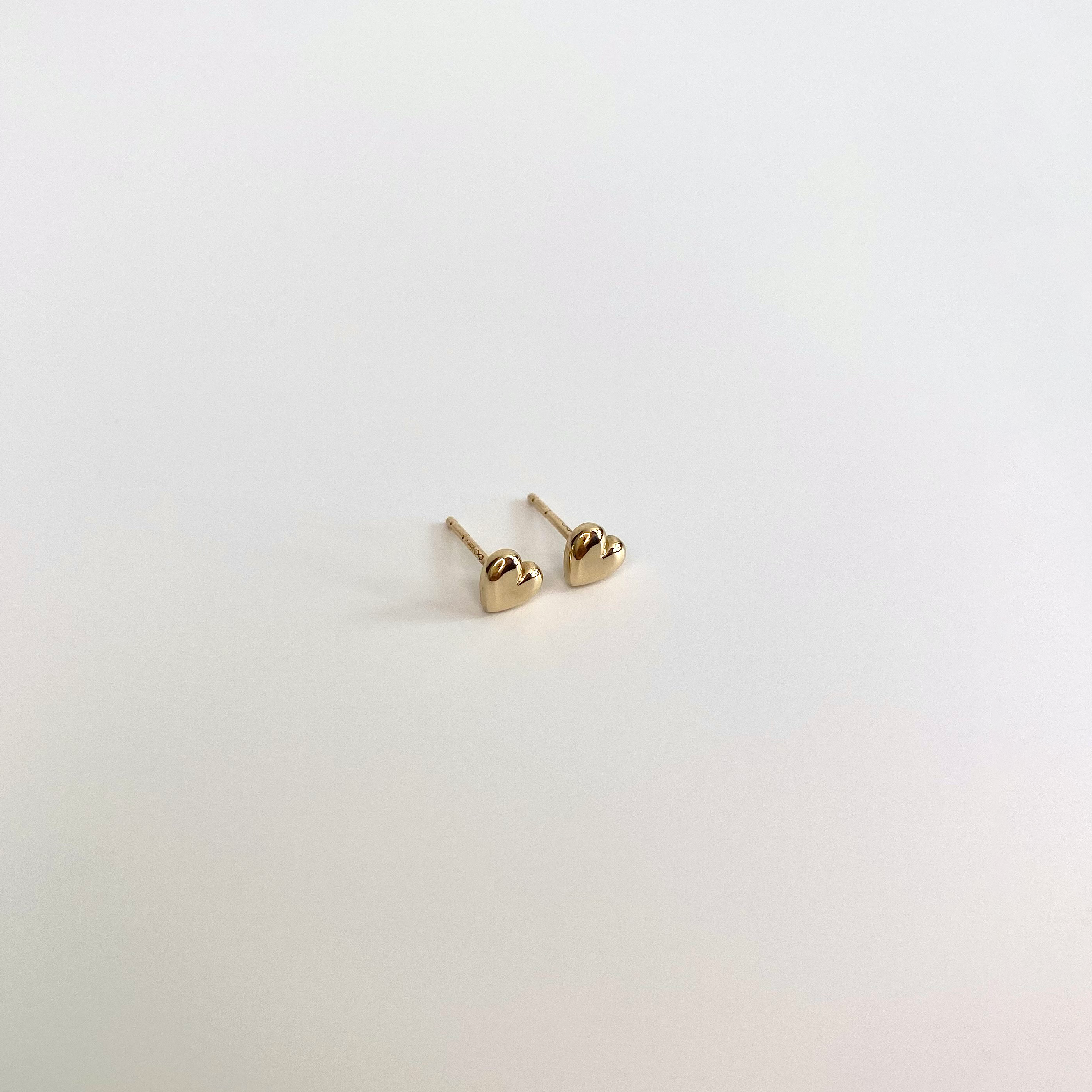 14 karat gold heart-shaped dainty studs on white background